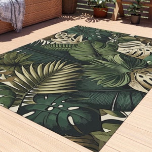 May include: A green and brown tropical leaf patterned outdoor rug on a wooden deck.