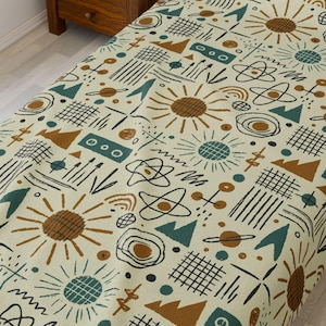 May include: A beige twin-sized bedspread with a geometric pattern featuring suns, stars, and abstract shapes in shades of brown, green, and black.