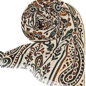 May include: Rolled beige scarf with a repeating pattern of brown, black, and green organic shapes. The scarf has a fringed edge and is displayed against a white background. The design includes paisley and floral elements.