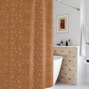May include: A rust-colored shower curtain with a repeating pattern of desert-themed illustrations, including cacti and geometric shapes. The curtain hangs in front of a white bathtub, creating a southwestern aesthetic.