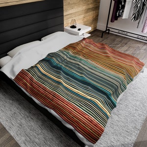 Könnte beinhalten: Ein weißer Bettbezug mit einem bunten Streifenmuster in Rot-, Orange-, Gelb-, Blau- und Grüntönen. Die Streifen sind wellenförmig und erzeugen ein dynamisches Design.
