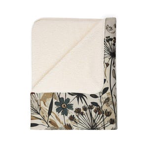 Whimsical Botanical Fleece Sherpa Blanket. Featuring an intricate design of various flowers, leaves, and branches in earthy tones. 2 sizes.