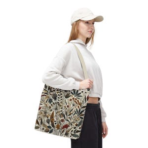 Whimsical Botanical Tote Bag. Featuring an intricate, unique and artistic design of various flowers, leaves, and branches in earthy tones.