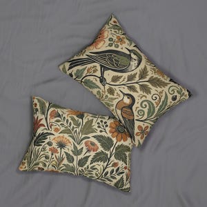 May include: Two decorative throw pillows featuring a floral and bird design. The pillows are beige with green, brown, and orange accents. The pattern includes stylised birds and flowers.