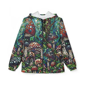 Puede incluir: Chaqueta con capucha y cremallera con un colorido diseño de setas. El diseño incluye varios tipos de setas en rojo, azul y blanco, sobre un fondo verde oscuro y azul. La chaqueta tiene un forro de capucha blanco.