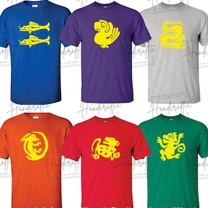 Puede incluir: Seis camisetas con fondos de colores diferentes y diseños gráficos amarillos. Los diseños incluyen un pez, un pájaro, una serpiente, un lagarto, un jaguar y un mono.