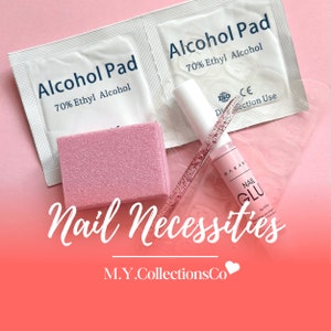 Op de afbeelding: Nagelverzorging essentials, waaronder twee alcoholpads, een roze vijl, een flesje nagellijm en een glittervijl. De tekst "Nail Necessities" en "M.Y.CollectionsCo" is ook zichtbaar.