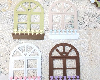 Puede incluir: Una colección de marcos de ventana de papel troquelado con partes superiores arqueadas y detalles en forma de corazón. Cada marco cuenta con una jardinera llena de pequeñas flores con forma de tulipán en varios colores pastel, incluyendo verde claro, beige, blanco y marrón.