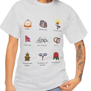 May include: A grey t-shirt with a white graphic of nine different symbols representing Nepalese culture. The symbols include a momo, dhaka topi, dashain tika, Nepal flag, Mt. Everest, sel roti, Pashupatinath temple, birthplace of Buddha, and rhododendron.