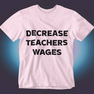 May include: Pink t-shirt with the text "DECREASE TEACHERS WAGES" printed in black.