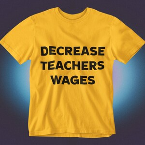 May include: A yellow t-shirt with the text "DECREASE TEACHERS WAGES" printed in black.