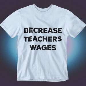 May include: A light blue t-shirt with the text "DECREASE TEACHERS WAGES" printed in black.