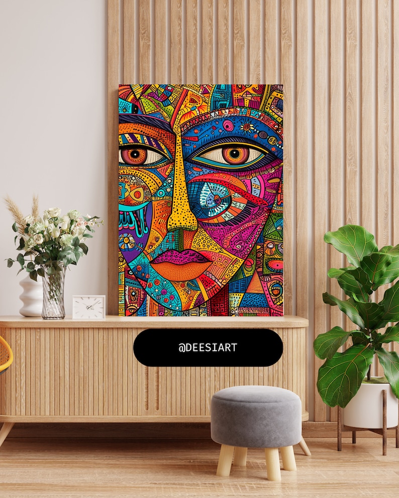 K&ouml;nnte beinhalten: Ein farbenfroher abstrakter Kunstdruck mit einem stilisierten Gesicht mit geometrischen Mustern und leuchtenden Farben, darunter Rot, Blau, Gelb, Gr&uuml;n und Pink. Der Druck ist gerahmt und h&auml;ngt an einer Wand.