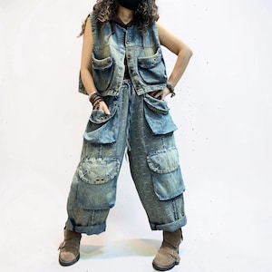 May include: A denim vest and matching pants set in a light blue wash. The vest has multiple pockets and a button-up front. The pants feature large cargo pockets and a drawstring waist. The outfit is paired with brown boots.