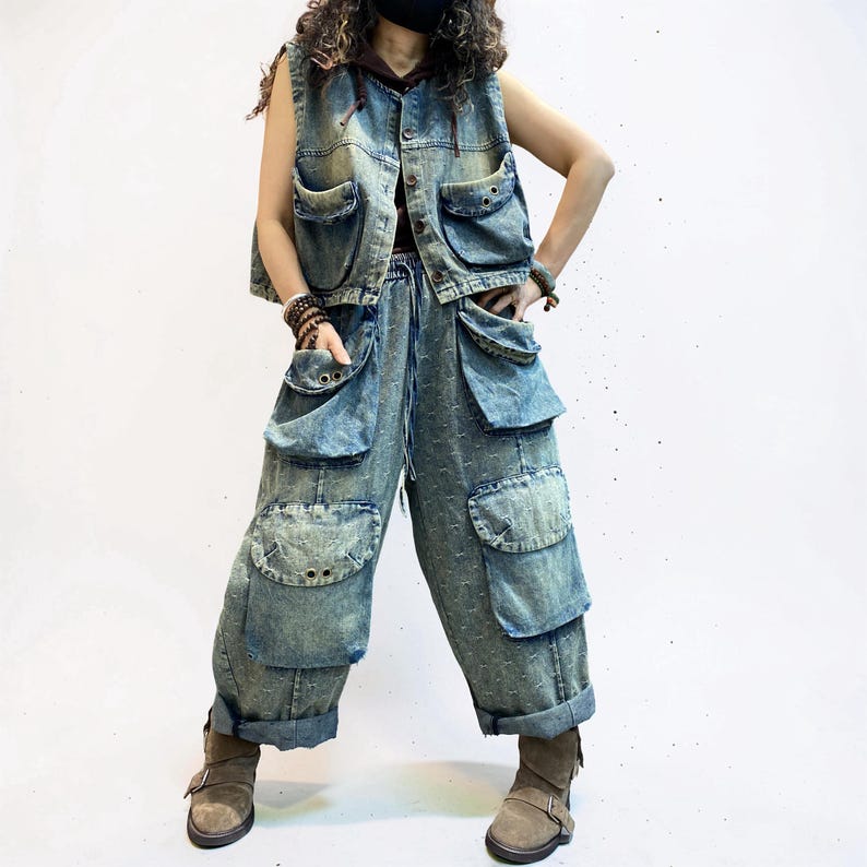 May include: A denim vest and matching pants set in a light blue wash. The vest has multiple pockets and a button-up front. The pants feature large cargo pockets and a drawstring waist. The outfit is paired with brown boots.