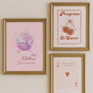 May include: Three framed art prints with gold frames. The prints feature a disco ball, cherries, and a playing card. Text on the prints includes "This Girl is a Speech therapist", "Progress is Sweet", and "You're a queen at communication."