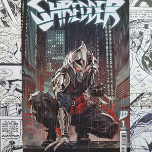 May include: A white ceramic mug with a black handle and the text "But First, Coffee" in a bold, black font. The mug is set against a blurred background, suggesting a cozy setting.