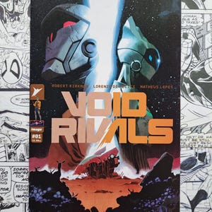 May include: A comic book titled Void Rivals #1 featuring two stylized robotic figures in a dark space setting. The cover displays the text Void Rivals, the names Robert Kirkman, Lorenzo De Felici, and Matheus Lopes, and an Image Comics logo.