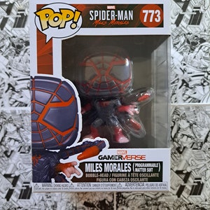 May include: A Marvel Gamerverse Miles Morales bobblehead figure in a clear plastic display case. The figure is wearing a black and red suit. The box has the words "Pop!" and "Spider-Man Miles Morales" printed on it.
