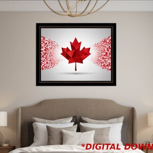 May include: A framed print of a red maple leaf, a symbol of Canada, with a white background. The leaf is made up of geometric shapes and appears to be dissolving into smaller pieces.