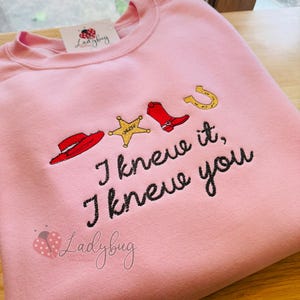 Embroidered "I Knew It I Knew You" sweatshirt featuring western rope lettering and a cowboy hat design on a cozy crewneck sweatshirt.