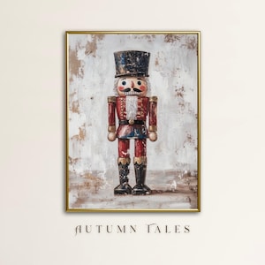 Puede incluir: Pintura enmarcada de un soldado cascanueces tradicional. El cascanueces está representado en rojo, azul y negro, con un ribete dorado. El fondo es blanco y marrón texturizado. Las palabras "AUTUMN TALES" están en la parte inferior.