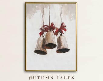 Op de afbeelding: Een ingelijst schilderij met drie bronzen klokken die aan touwen hangen, elk met een rode strik. Het kunstwerk heeft een neutrale achtergrond en is goudkleurig omlijst. De tekst "AUTUMN TALES" staat onderaan.