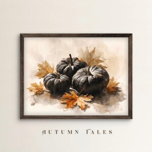 May include: Watercolor painting of three dark gray pumpkins surrounded by autumn leaves in shades of orange and brown. The artwork is framed in a dark brown wooden frame. The text "AUTUMN TALES" is at the bottom of the image.