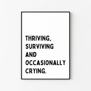 May include: Black and white typography print with the text "THRIVING, SURVIVING AND OCCASIONALLY CRYING."