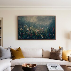 a living room with a white couch and a painting on the wall