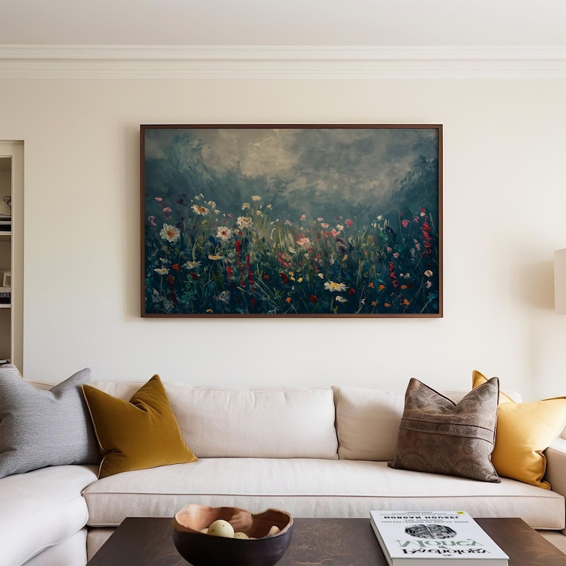 a living room with a white couch and a painting on the wall