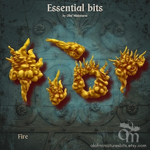 Könnte beinhalten: Fünf goldene Feuerminiaturen in verschiedenen Flammenformen. Der Text "Essential bits" und "Fire" sind sichtbar. Der Etsy-Shop-Name "Olaf Miniatures" wird ebenfalls angezeigt.