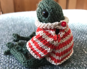 Knitted pocket frog in a chunky red and cream striped jumper.