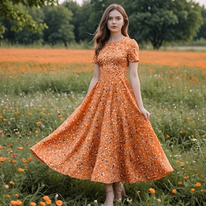 May include: A midi-length dress in a vibrant orange hue featuring a dense pattern of small white and black floral accents. The garment has short sleeves, a round neckline, and a fitted bodice that transitions into a full, flared skirt.