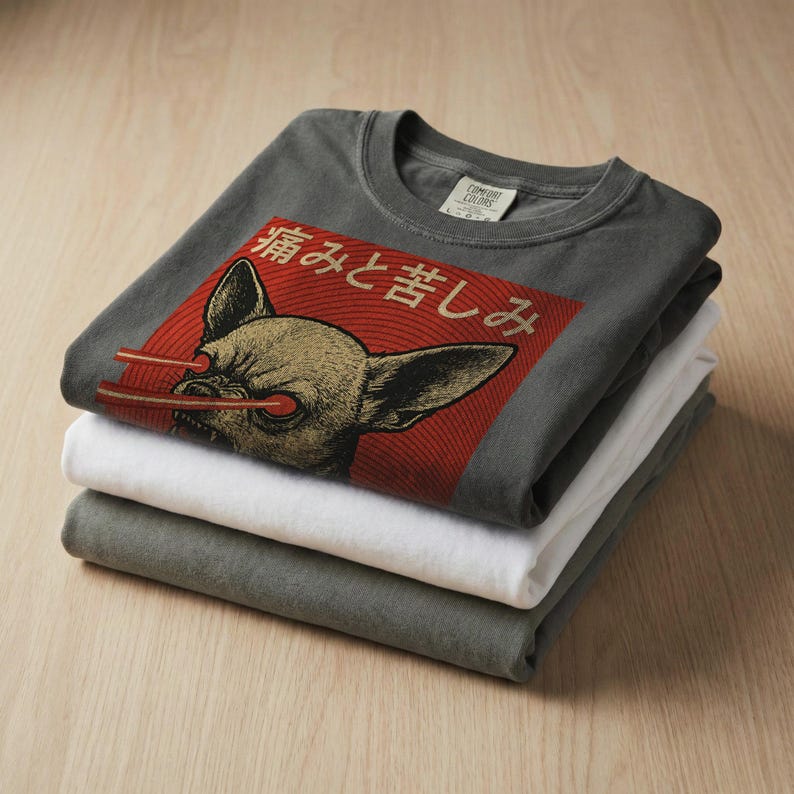 Vintage-style bootleg tshirt design featuring an angry chihuahua shooting red laser beams from its eyes, set against bold Japanese poster graphics with kanji text, distressed 90s aesthetic, and the word “RAGE” in large block letters. Perfect for fans of weirdcore, dreamcore, Harajuku fashion, and unhinged shirts. Printed on soft comfort colors cotton.