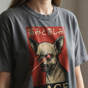 Vintage-style bootleg tshirt design featuring an angry chihuahua shooting red laser beams from its eyes, set against bold Japanese poster graphics with kanji text, distressed 90s aesthetic, and the word “RAGE” in large block letters. Perfect for fans of weirdcore, dreamcore, Harajuku fashion, and unhinged shirts. Printed on soft comfort colors cotton.