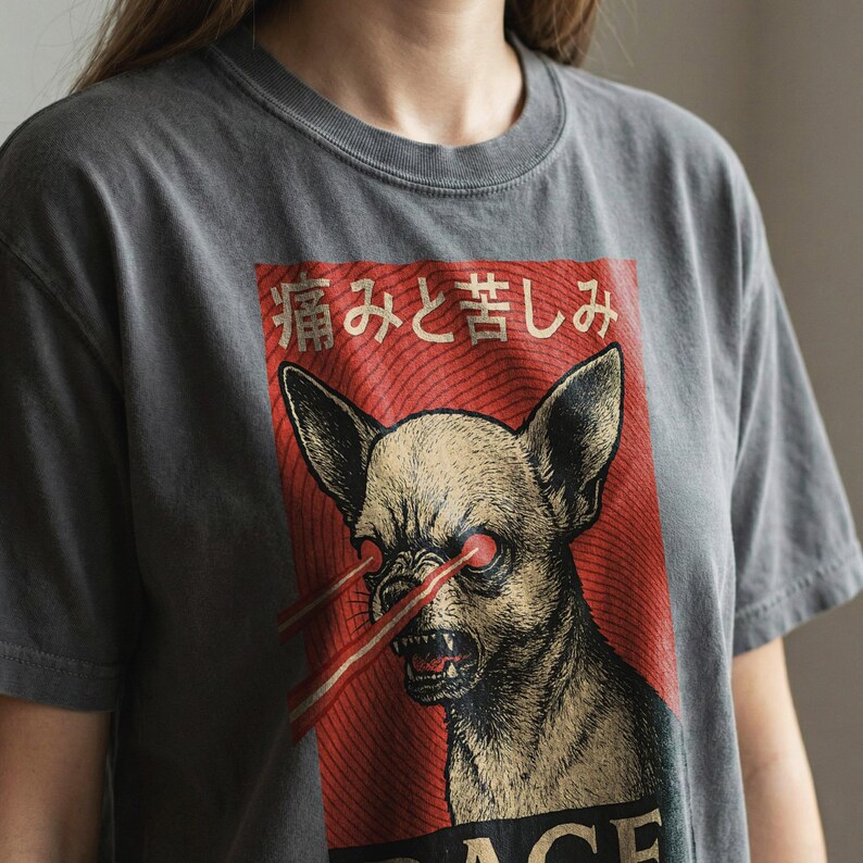 Vintage-style bootleg tshirt design featuring an angry chihuahua shooting red laser beams from its eyes, set against bold Japanese poster graphics with kanji text, distressed 90s aesthetic, and the word “RAGE” in large block letters. Perfect for fans of weirdcore, dreamcore, Harajuku fashion, and unhinged shirts. Printed on soft comfort colors cotton.