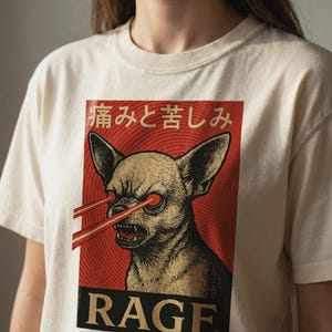 Vintage-style bootleg tshirt design featuring an angry chihuahua shooting red laser beams from its eyes, set against bold Japanese poster graphics with kanji text, distressed 90s aesthetic, and the word “RAGE” in large block letters. Perfect for fans of weirdcore, dreamcore, Harajuku fashion, and unhinged shirts. Printed on soft comfort colors cotton.