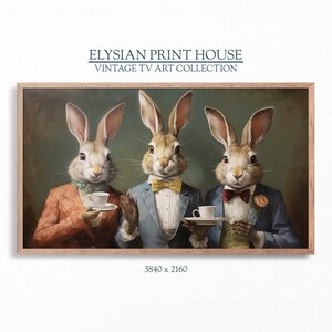 May include: Three rabbits dressed in suits and bow ties are sitting at a table, each holding a teacup. The rabbits are wearing a red suit, a blue suit, and a green suit. The background is a green wall.