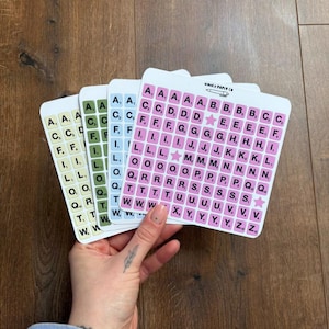 May include: Four sets of alphabet letter stickers in different colours: green, blue, light blue, and pink. Each set has a star sticker.