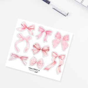 Op de afbeelding: Een vel roze aquarel strik stickers met de tekst "Wonky Paper Co."