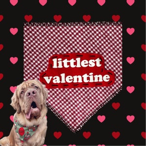 May include: A Neapolitan Mastiff dog wearing a Valentine's Day bandana. The dog is in front of a red and white houndstooth patterned bandana with the words "littlest valentine" in white. The background is black with red and pink hearts.