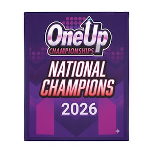 May include: A purple blanket with the text "One Up Championships National Champions 2026" in white and red. The blanket has a geometric design and a small star in the lower right corner.