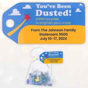 May include: A blue and yellow tag with the text "You've Been Dusted!" and a star graphic. Below is a small bag filled with blue and green decorations and a yellow rubber duck. The tag reads "A little surprise to brighten your cruise."