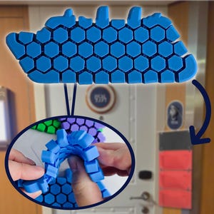 Könnte beinhalten: Ein blaues, flexibles, wabenförmiges Panel, das in verschiedene Formen gebogen und gefaltet werden kann. Das Panel besteht aus einem weichen, biegsamen Material und hat eine strukturierte Oberfläche.
