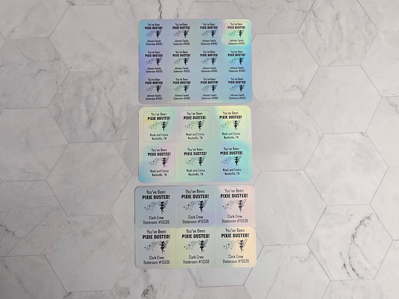 May include: A set of 12 iridescent stickers with the text "You've Been Pixie Dusted!" and a fairy illustration. The stickers are in three rows of four, with each row having a different color scheme. The text "Clark Crew" and "Stateroom #10530" are printed on the bottom row of stickers.
