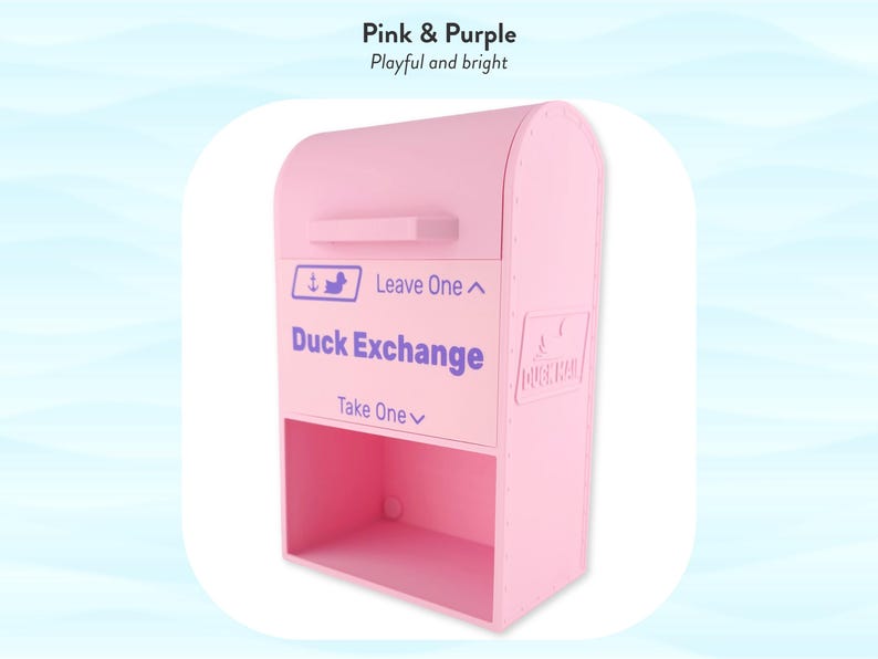 May include: A pink and purple Duck Exchange box with the text "Duck Exchange" and instructions to "Leave One" and "Take One." The box has a mailbox-like design with a top compartment and a lower open shelf. The text "Pink & Purple" and "Playful and bright" are at the top.