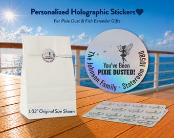 Puede incluir: Pegatinas holográficas redondas con un gráfico de hada, estrellas y el texto 'You've Been PIXIE DUSTED!', 'The Johnson Family' y 'Stateroom 10586'. Una bolsa de papel blanca muestra una pegatina, con una referencia de tamaño de 2,62 cm.