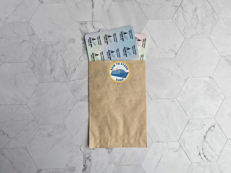 May include: A brown paper bag with a sticker that says "Bow to Stern Shop" and a blue and white illustration of a boat. The bag is filled with a stack of colorful tickets.