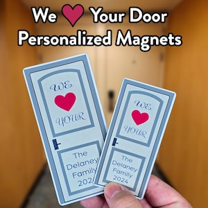 Puede incluir: Dos imanes de puerta personalizados con un diseño de puerta azul y blanco. El imán más grande dice "We Love Your" con un corazón rojo y "The Delaney Family 2024". El imán más pequeño dice "We Love Your" con un corazón rojo y "The Delaney Family 2024".